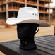 White cowboy hat on a black mannequin head with a blurred construction site background